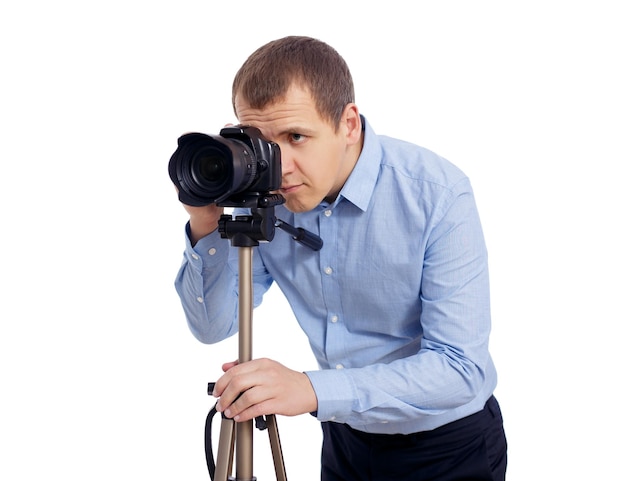 Fotógrafo ou cinegrafista masculino tirando fotos ou gravando vídeos com a câmera dslr moderna no tripé