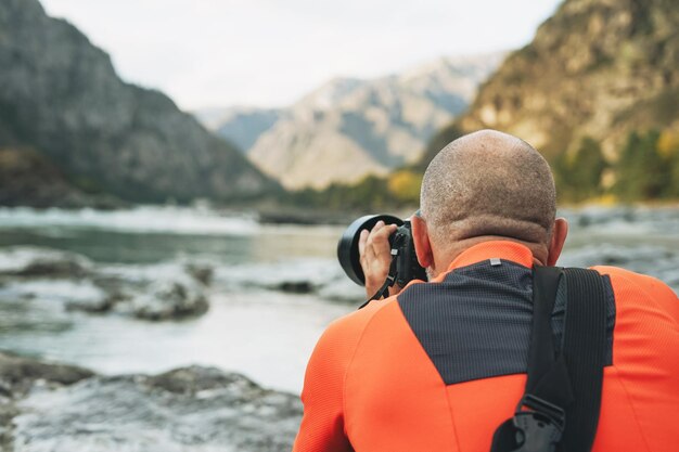 Fotógrafo de paisajes en el trabajo Fotógrafo dispara hermosas vistas de las montañas de Altai del río Katun