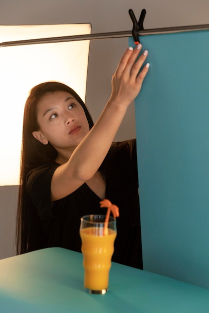 Foto fotógrafo de producto femenino joven en su estudio