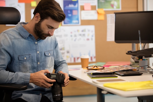 Foto fotógrafo profesional con cámara en la oficina creativa