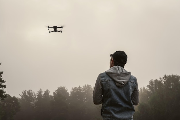 Fotógrafo profesional tomando fotos de un hombre con drones tomando fotografías aéreas en el bosque Hombre controlando su dron en el fondo del bosque de montaña