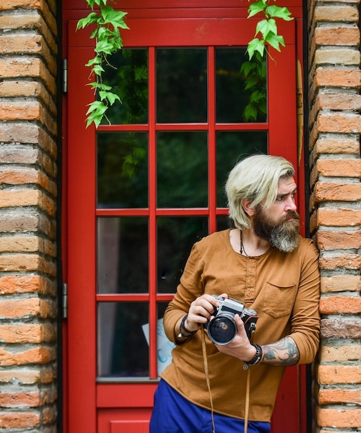 Fotógrafo profesional uso cámara vintage Negocio de fotografía Carrera creativa Fotógrafo creativo fondo urbano estilo de arquitectura irlandesa Sesión de fotos Hombre brutal con cámara retro