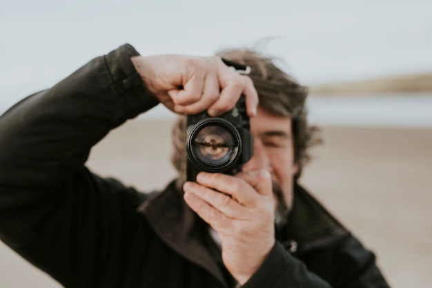 Foto fotógrafo sênior tira uma foto de paisagem da natureza