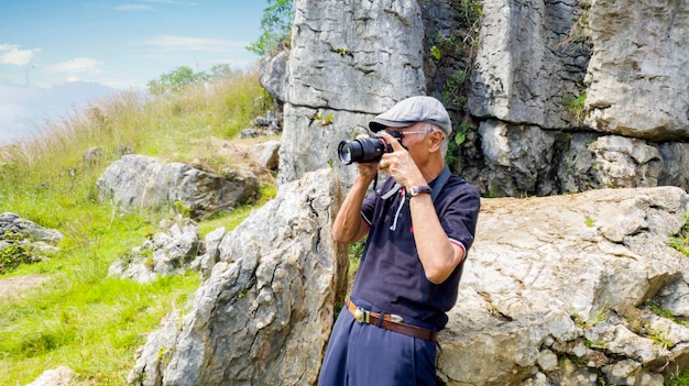 Fotógrafo senior tomando una foto cerca de calizas