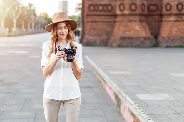 Fotógrafo de sexo femenino al aire libre revisando las imágenes en la cámara.