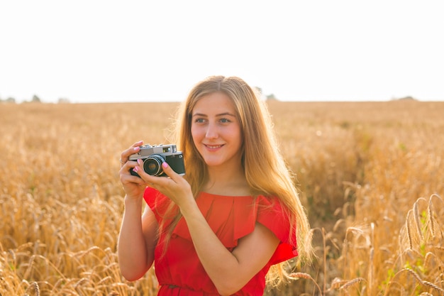 Fotógrafo de sexo femenino en el campo con una cámara tomando fotos