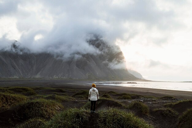 Fotógrafo sobre una colina verde en la península de Stokksnes, en el sureste de Islandia