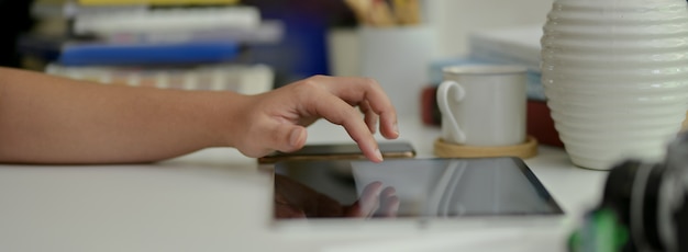 Fotógrafo tocando la tableta simulada mientras trabajaba en la mesa de trabajo