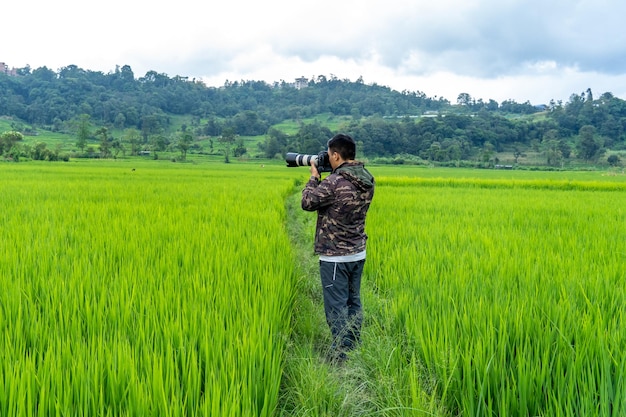 Un fotógrafo toma una foto en un campo de arroz.