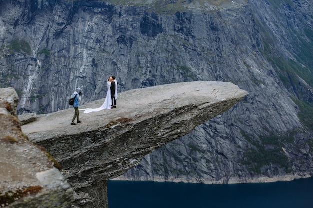 El fotógrafo toma una foto de una pareja de recién casados en un trozo de roca en Noruega llamada The Troll's Tongue