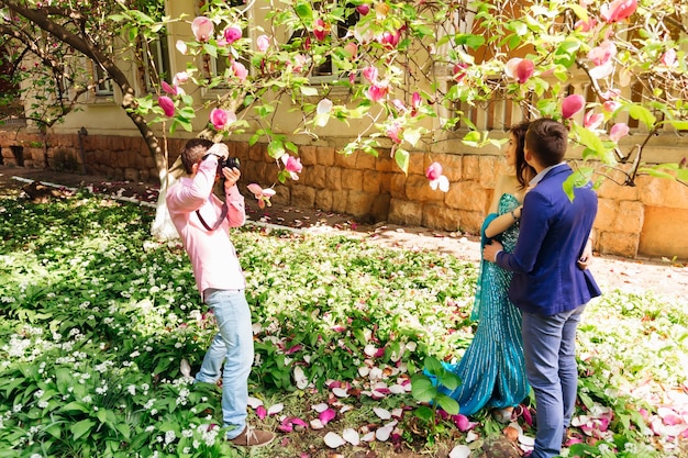 Fotógrafo toma fotografías de una pareja enamorada cerca de magnolia y el edificio