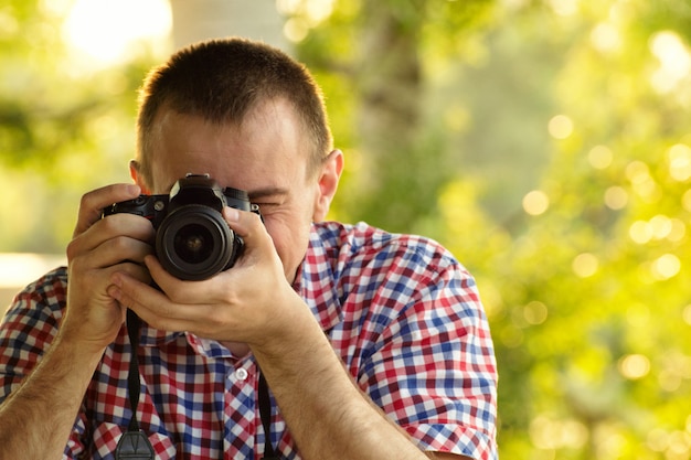 El fotógrafo toma imágenes contra la superficie de la vegetación, vista frontal