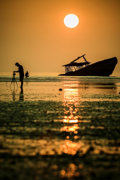 Foto fotógrafo tomando una fotografía de abandono barco hundido en phuket sur de tailandia