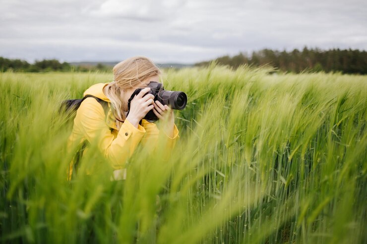 Fotógrafo tomando fotografías del campo de trigo verde