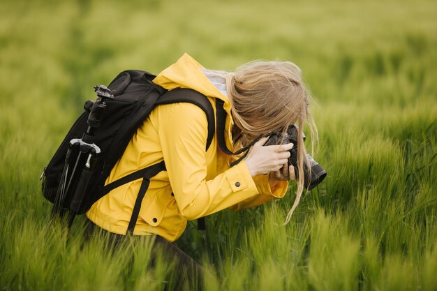 Fotógrafo tomando fotos de orejas en campo de trigo