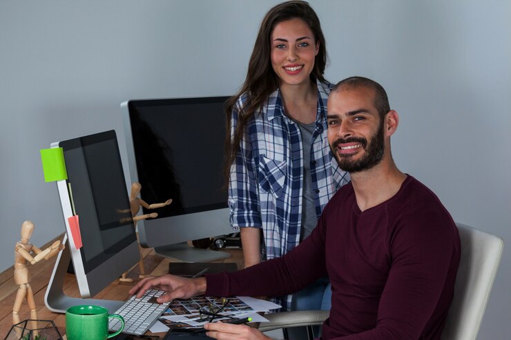 Foto fotógrafo trabajando en su escritorio con colega