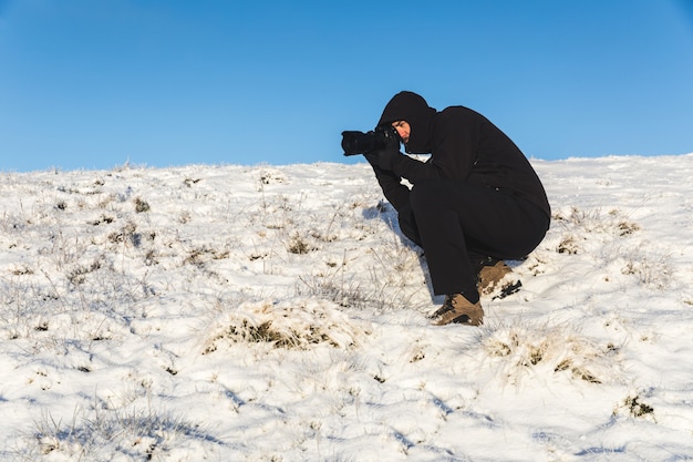 Fotógrafo en el trabajo en la nieve en invierno