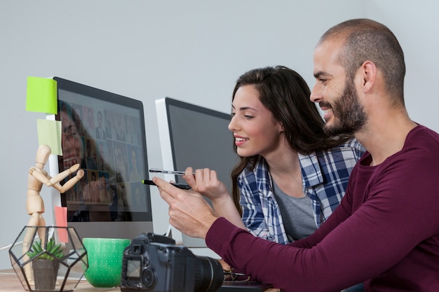 Fotógrafo, trabalhando em sua mesa com o colega