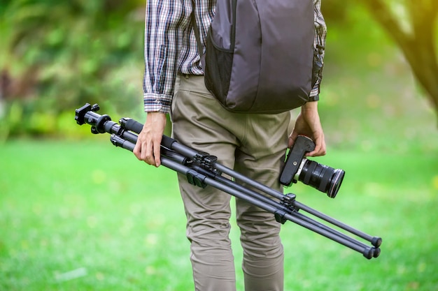 Fotógrafo con un trípode de cámara en la naturaleza para el fondo