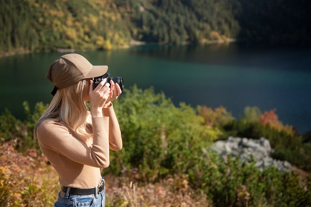 Fotógrafo turista viajante em pé no topo verde da montanha