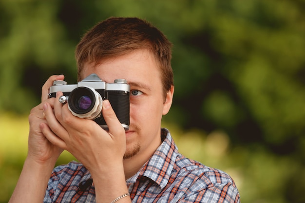 Fotógrafo turístico con cámara de fotos disparando en el parque.