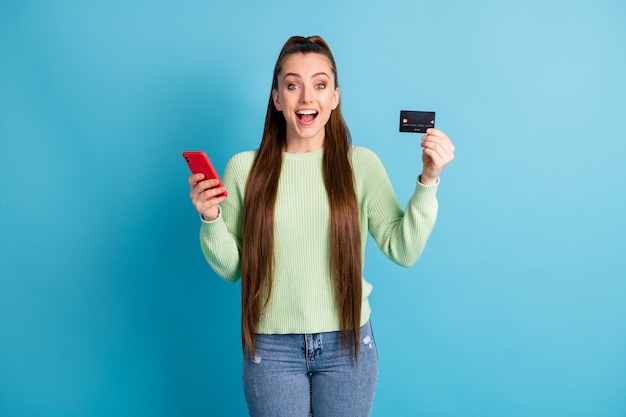 Fotoporträt einer schreienden Frau, die eine Telefonbankkarte isoliert auf pastellblauem Hintergrund hält