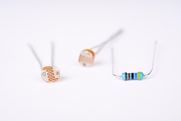 Fotoresistor e resistor de peças eletrônicas no fundo branco.