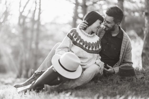 Fotos em preto e branco Lindo casal hipster com bicicleta Casal vestindo lindos chapéus e blusas