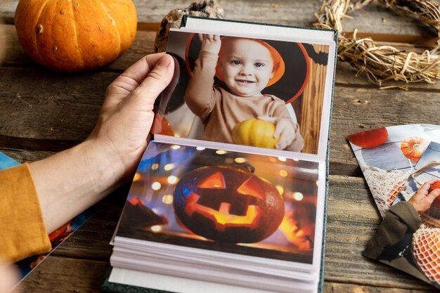Fotos impresas de Halloween en álbum de imágenes álbum de fotos con la mano de una mujer