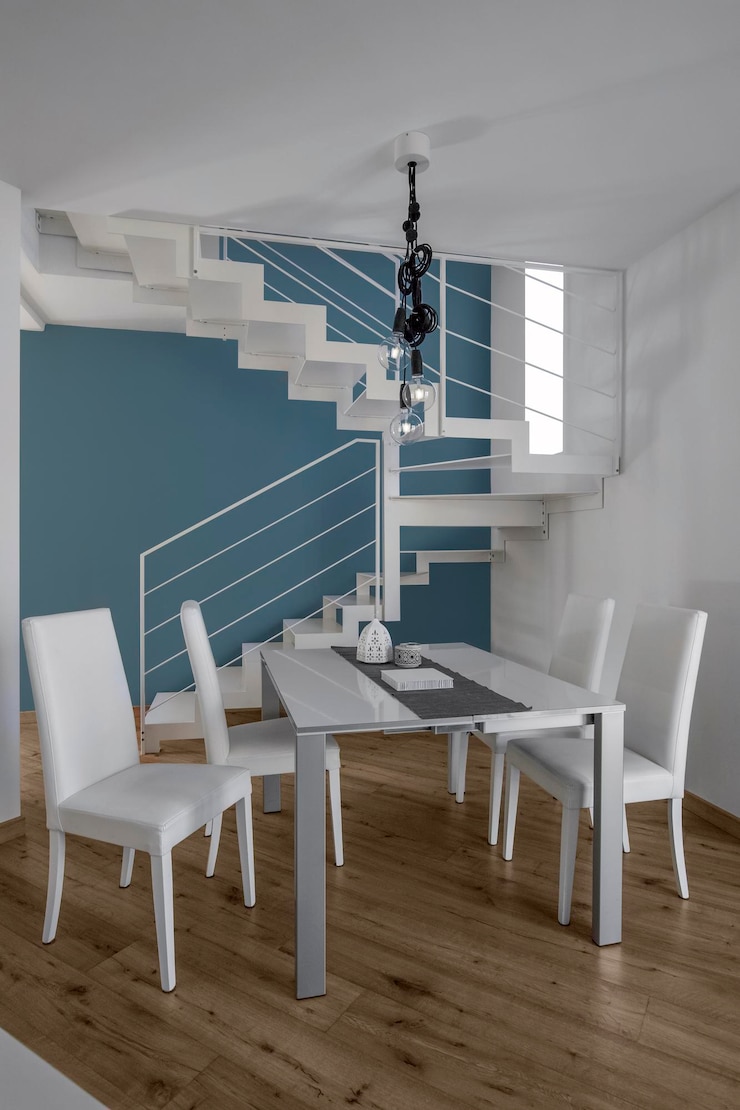 Foto fotos de interiores de un apartamento moderno en primer plano la mesa de comedor con sillas de cuero el piso es de madera en el fondo la escalera de hierro
