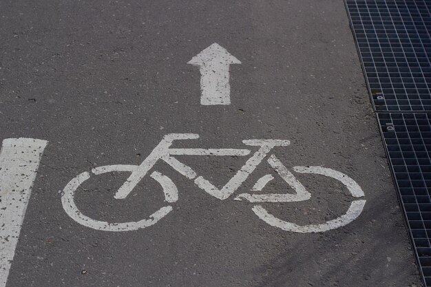 Fotoschild auf Bürgersteigfahrrad mit weißem Farbpfeil Straßenverkehr Stadtverkehr Radfahrerstraße