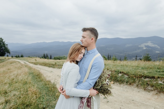 Fotoshooting von Braut und Bräutigam in den Bergen. Hochzeitsfoto im Boho-Stil.