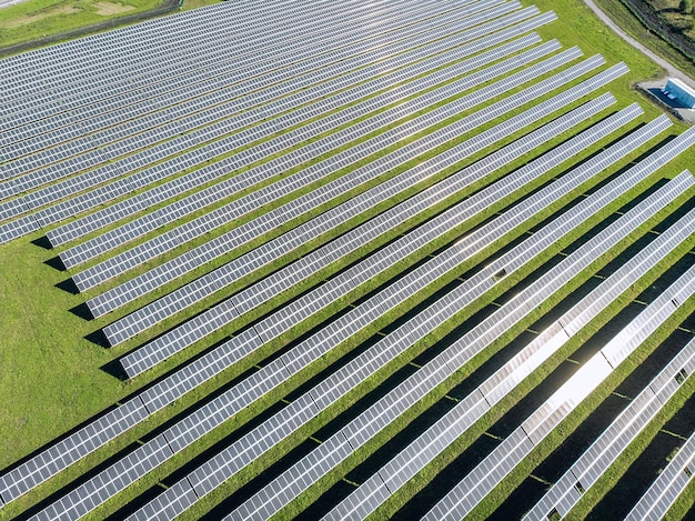 Fotovoltaica solar de vista aérea, matriz de filas de plantas solares en el césped de la granja. Vista superior