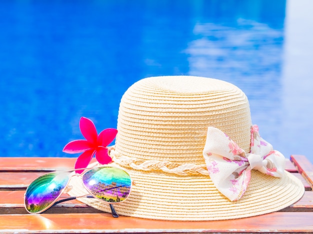 Foto fower com chapéu de verão e óculos de sol à beira da piscina