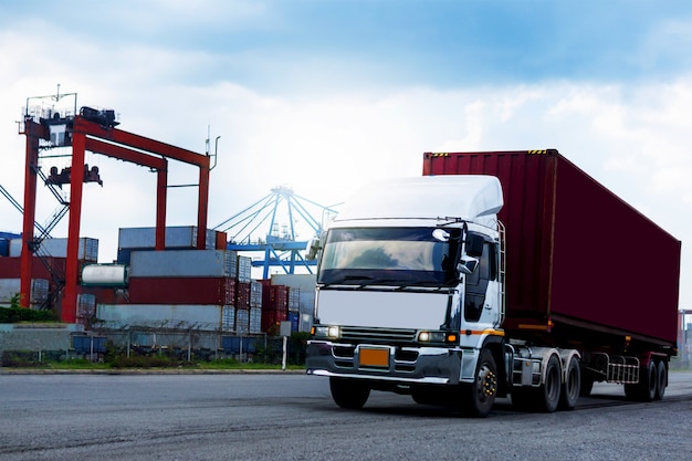 Fracht-roter Container-LKW in der Schiffshafen Logistik