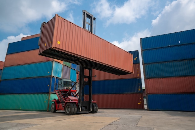 Frachtcontainer für Überseeschifffahrt in Werft mit schwerer Maschine.