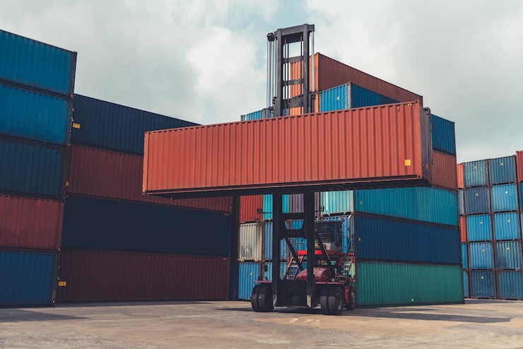 Foto frachtcontainer für überseeschifffahrt in werft mit schwerer maschine.