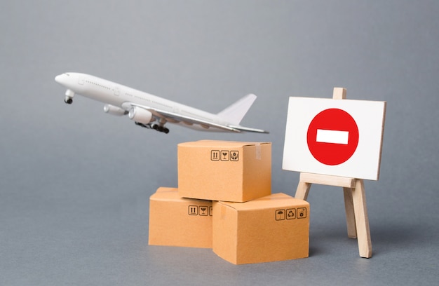 Frachtflugzeug mit Kisten und Staffelei mit Restriktionsschild. Beschränkungen für den Export von Medizinprodukten