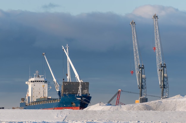 Frachtschiff vor Anker im arktischen Hafen Winterzeit Eisnavigation Ladevorgang läuft