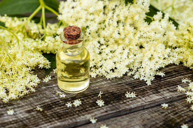 La fragante flor de saúco con aceite esencial en una mesa de madera