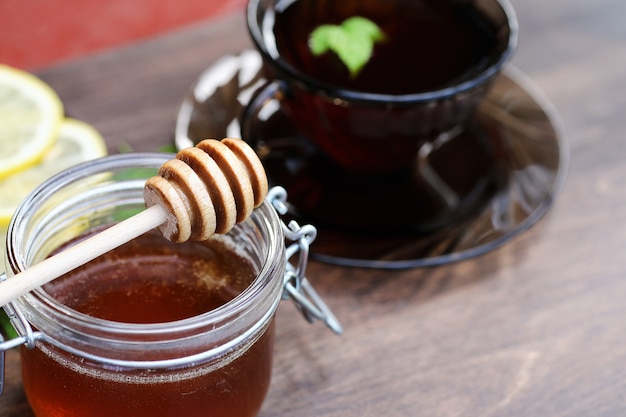 Una fragante miel fresca con una taza de té negro.