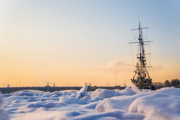 Fragata limitada pelo gelo. frio extremo. o conceito de refrigeração global. navio congelado no gelo no rio neva. são petersburgo.