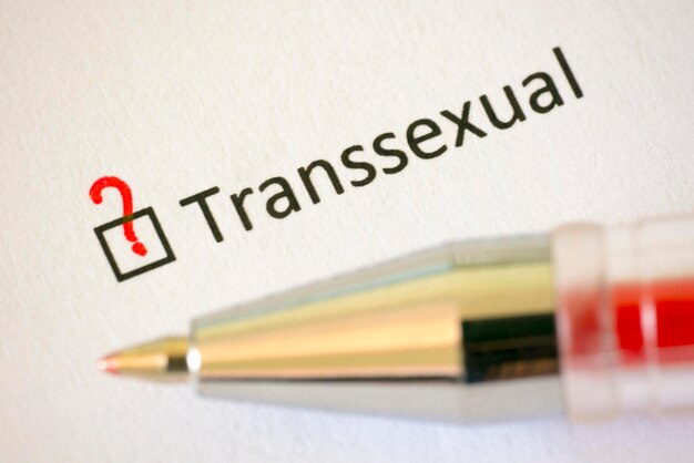 Fragebogen Rotstift und die Aufschrift TRANSSEXUAL mit einem Fragezeichen auf dem weißen Papier