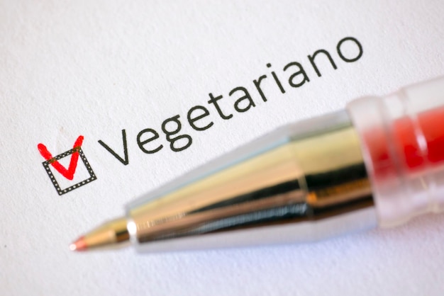 Foto fragebogen rotstift und die aufschrift vegetarian mit häkchen auf dem weißen papier