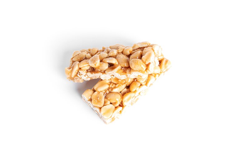 Frágil de amendoim isolado no fundo branco. Amendoim em caramelo. Barra de chocolate natural. Foto de alta qualidade