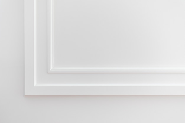 Fragment des klassischen weißen Interieurs mit installierten Wandpaneelen, die mit Formteilen verziert sind Die letzte Phase der Fertigstellungsarbeiten in der Wohnung