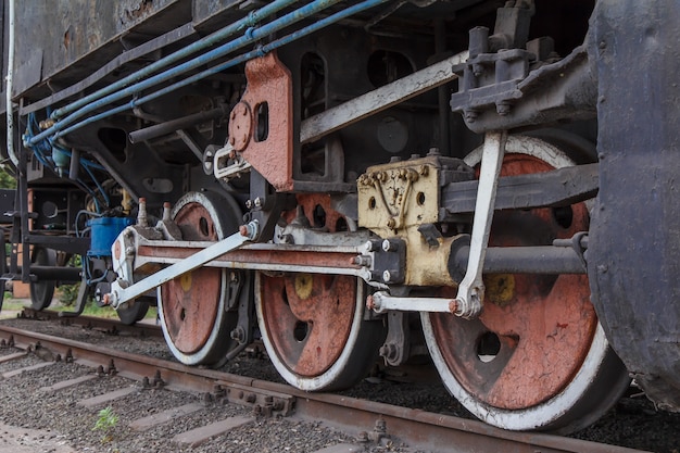 Fragment einer alten rostigen Lokomotive, die auf Bahngleisen steht