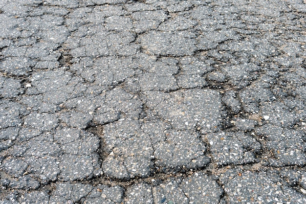 Fragment einer russischen Landstraße mit einem rissigen Asphalt Alte gebrochene Asphalttextur