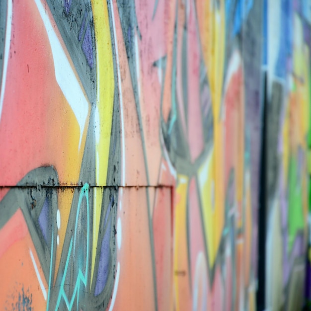 Fragment von Graffiti-Zeichnungen Die alte Wand, die mit Farbflecken im Stil der Street-Art-Kultur dekoriert ist Farbige Hintergrundtextur in warmen Tönen