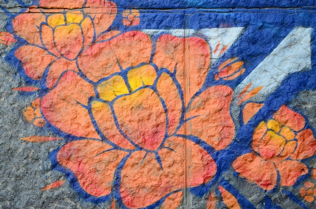 Fragment von Graffiti-Zeichnungen Die alte Wand, die mit Farbflecken im Stil der Street-Art-Kultur dekoriert ist Orange Blume